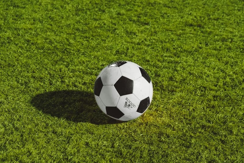 Friends playing football on a turf